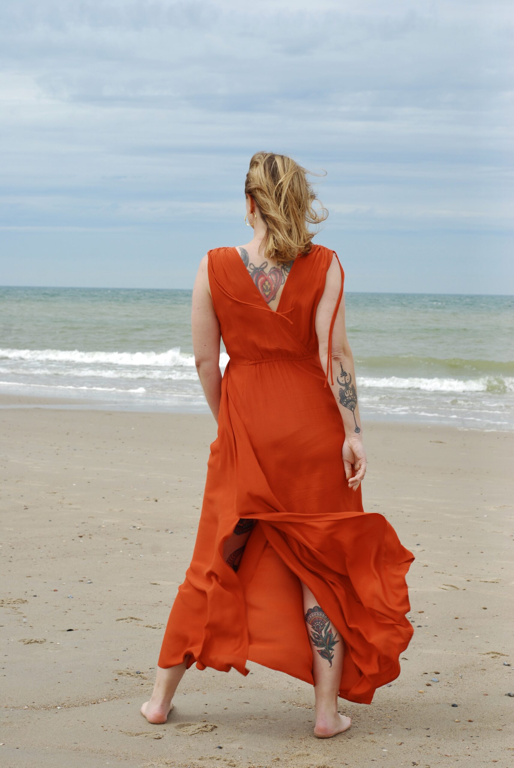 Frau in rotem Kleid am Strand